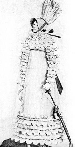 394. Из французского модного журнала, около 1815 г. Это платье с кружевными воланами вокруг шеи, на рукавах и по нижнему краю юбки скрывает естественные пропорции тела. Модель дополняет высокий чепец. 